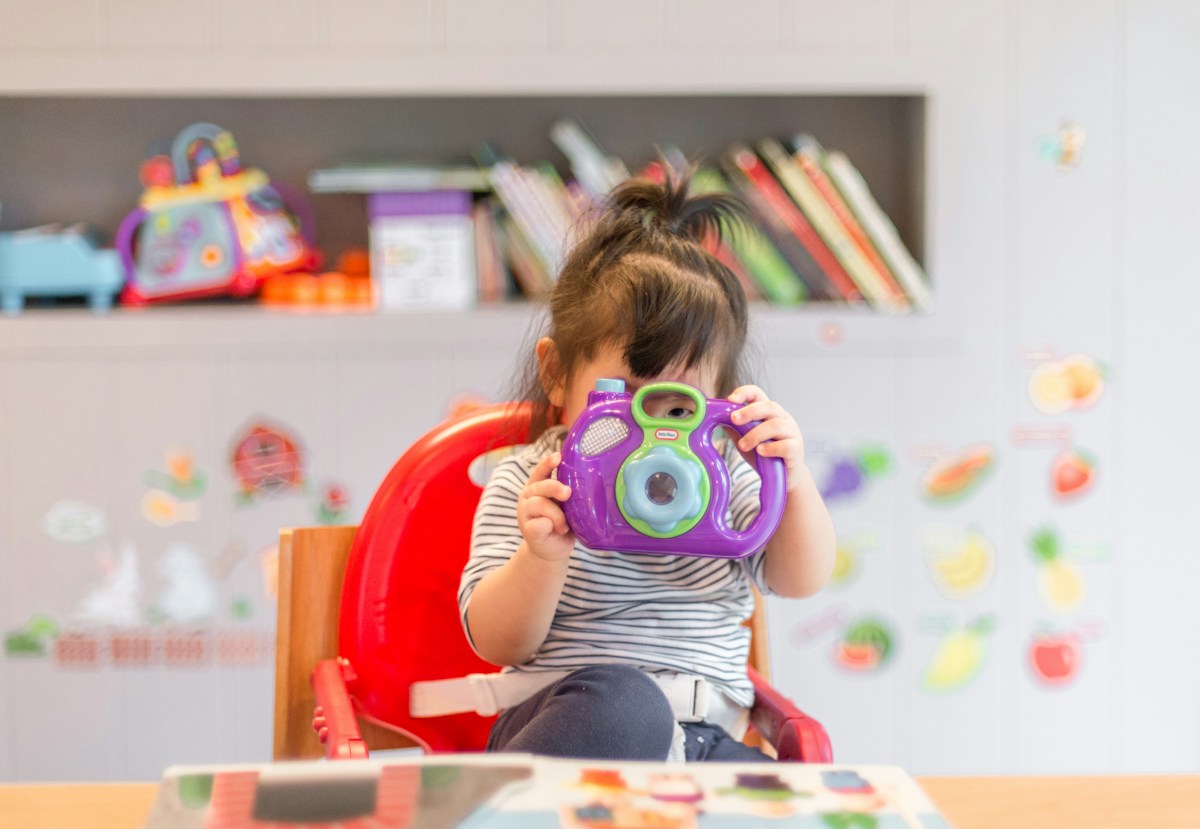 A child exploring a toy camera during creative play